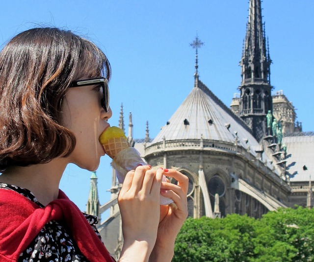 Eine junge Touristin isst vor der Kathedrale Notre-Dame in Paris ein Eis.   | Foto: dpa