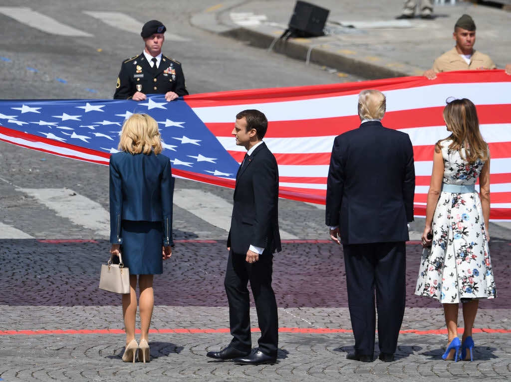 Ehepaar Trump und Ehepaar Macron stehen vor der amerikanischen Nationalflagge