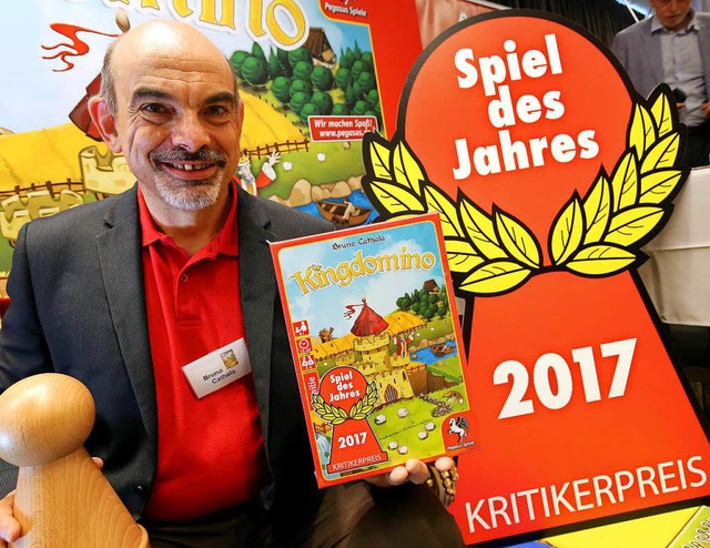 Sieger Bruno Cathala posiert stolz mit...rnten Spiel &#8222;Kingdomino&#8220;.  | Foto: dpa