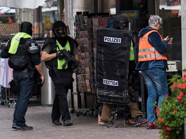 Polizisten durchsuchen die Innenstadt.  | Foto: dpa