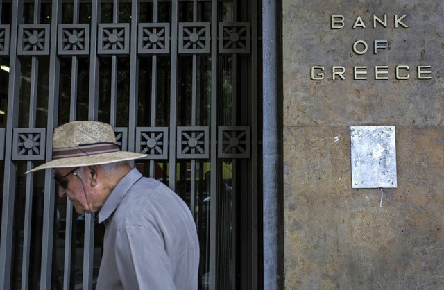 Ein lterer Mann luft an der griechischen Nationalbank in Athen vorbei.  | Foto: dpa