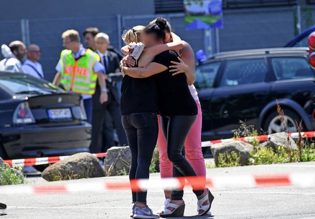 Trauernde Frauen umarmen sich vor dem Club Grey in Konstanz.  | Foto: dpa