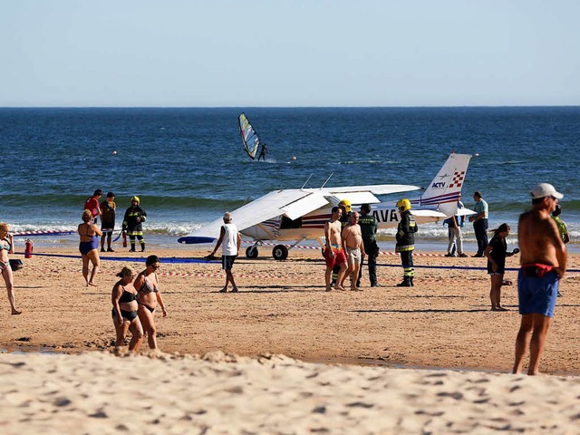 Ermittler untersuchen die Cessna am Strand.   | Foto: dpa