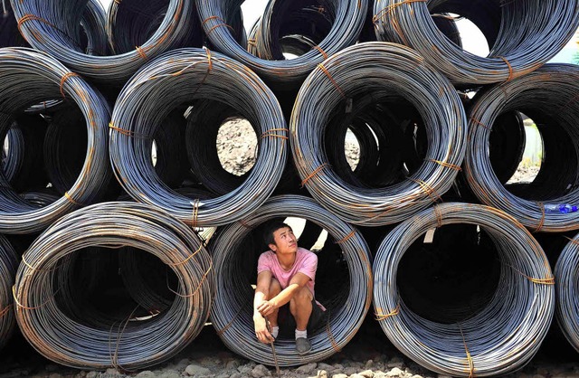 Nichts zu tun? Ein Mann in Shenyang wa...auf Kunden, die Metall kaufen wollen.   | Foto: dpa