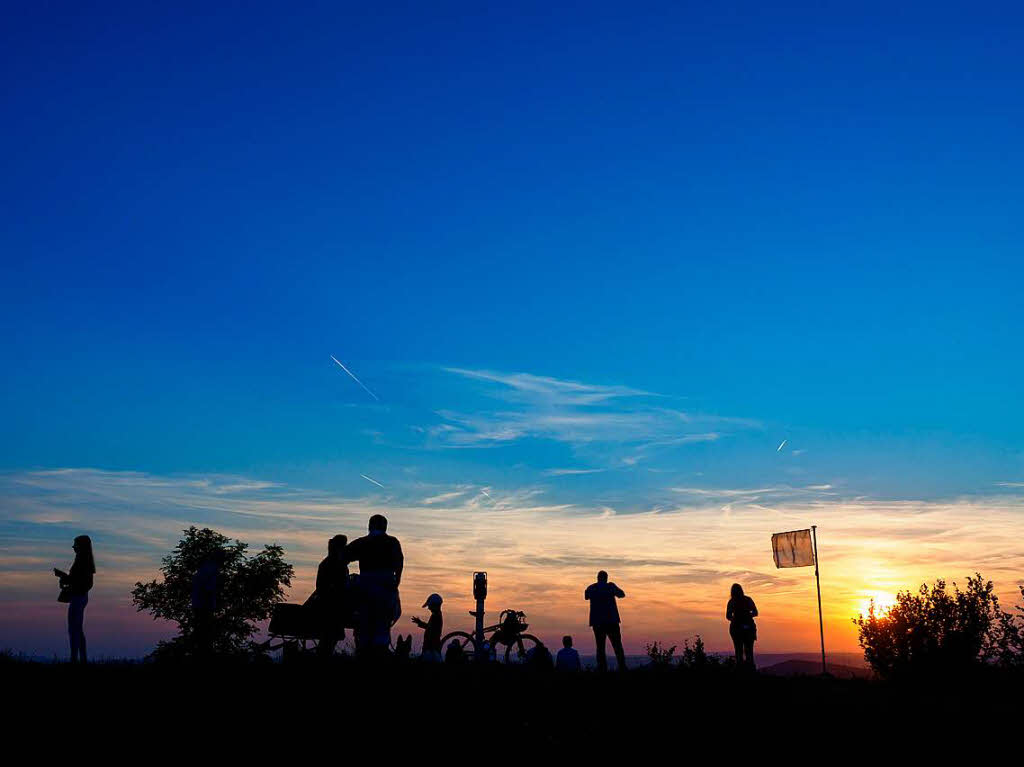 Mehrere Wanderer sind  auf dem Staffelberg bei Bad Staffelstein (Bayern) whrend des Sonnenuntergangs zu sehen. Viele Schaulustige warteten auf dem Staffelberg auf den Aufgang des Mondes, um die partielle Mondfinsternis zu sehen.