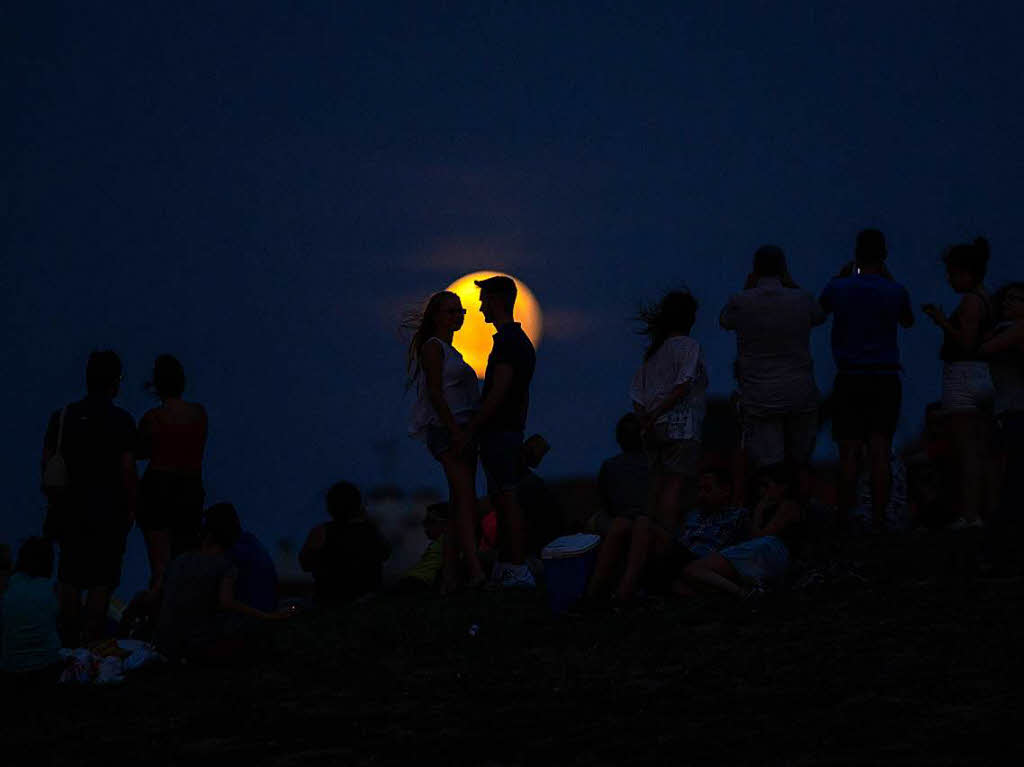 Menschen betrachten  im Cerro Del Tio Pio Park inMadrid (Spanien) die partielle Mondfinsternis .