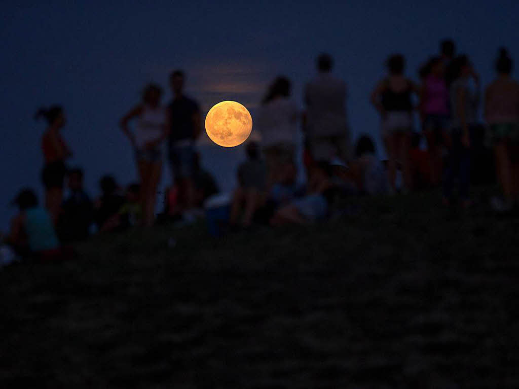 Menschen betrachten  im Cerro Del Tio Pio Park inMadrid (Spanien) die partielle Mondfinsternis .
