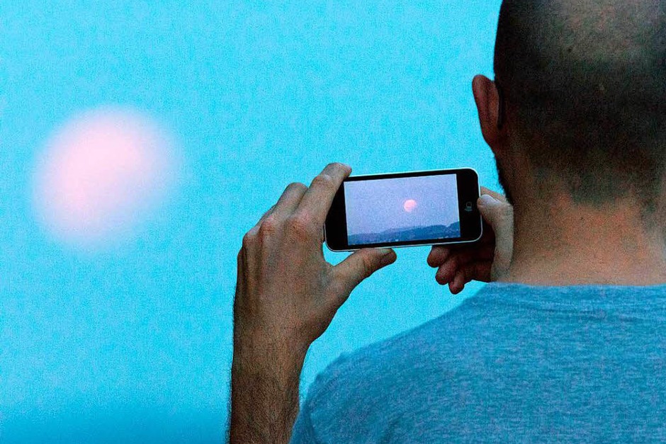 Ein Mann fotografiert in Bielefeld (Nordrhein-Westfalen) bei einer partiellen Mondfinsternis den Mond mit seinem Handy. (Foto: dpa) Ein Mann fotografiert in Bielefeld (Nordrhein-Westfalen) bei einer partiellen Mondfinsternis den Mond mit seinem Handy. (Foto: dpa)