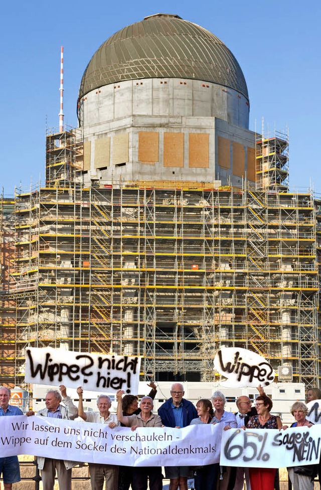 Demonstranten mit Plakaten und einem T...tehen am Montag  am Berliner Schloss.   | Foto: dpa