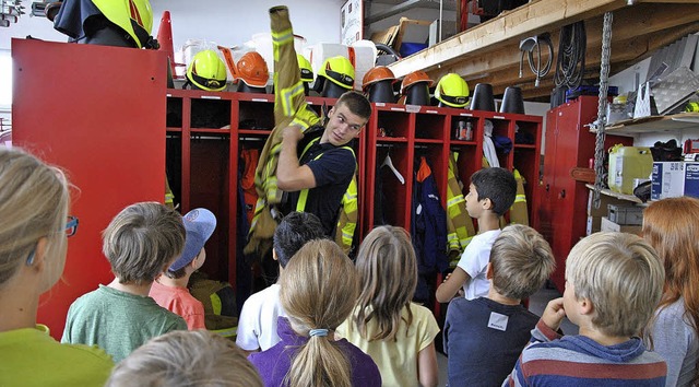 Moritz Watermann zeigt den Kindern, wa... zu einer Feuerwehrausrstung gehrt.   | Foto: Ralph Fautz