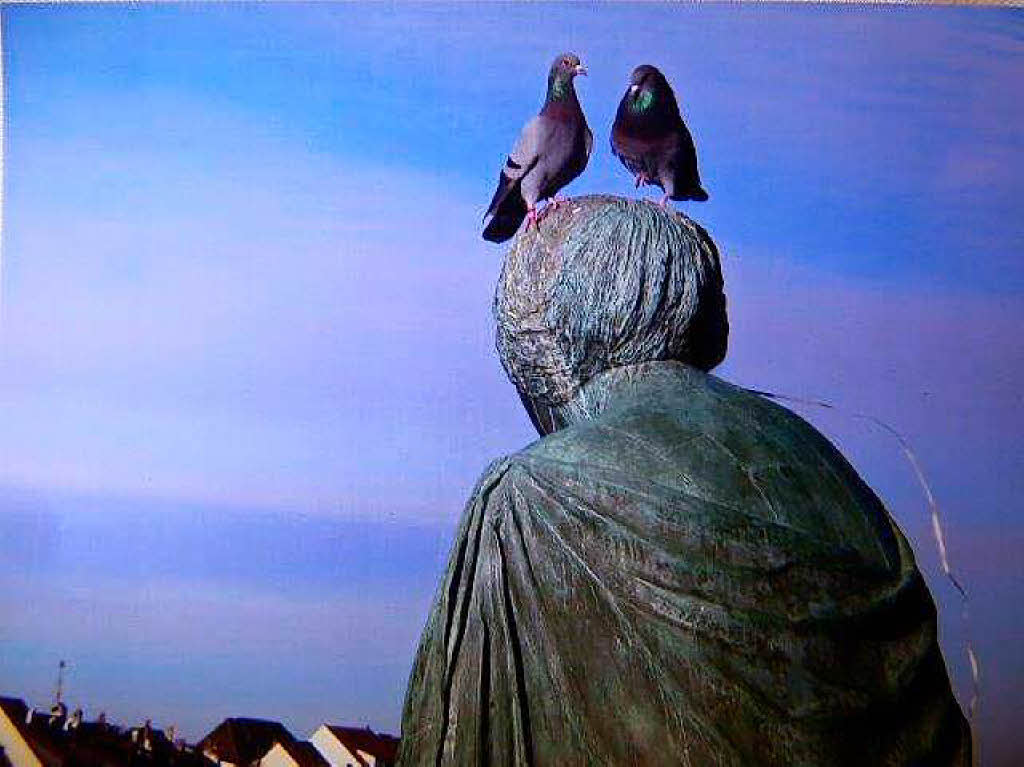 Karin Feger: „Schaut Helvetia in die Ferne, glaubt man ihr den Weitblick gerne!“. Zu sehen ist die Bronze-Skulptur „Helvetia auf der Reise“  von Bettina Eichin 1980  (auf der Mittleren Brcke in Basel).