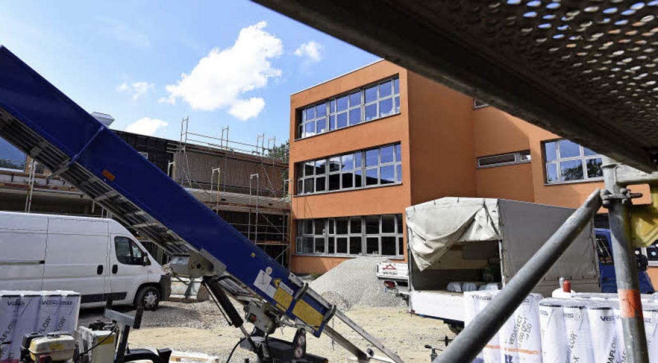 Das alte orangefarbene Schulhaus wird noch saniert.  | Foto: Rita Eggstein