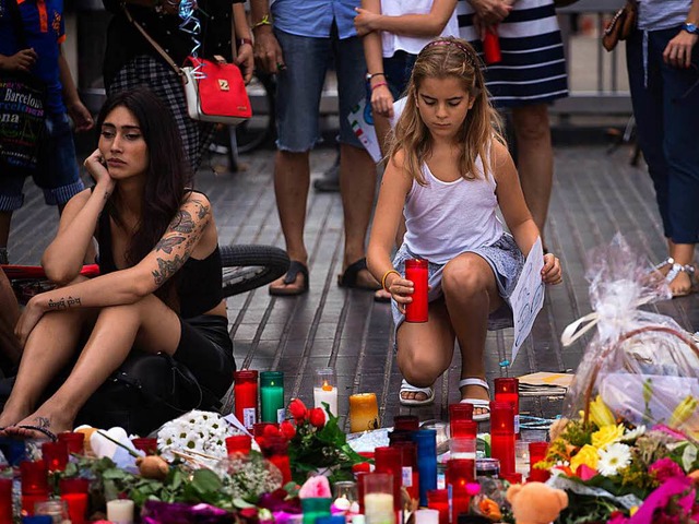 Ein Mdchen stellt eine Kerze fr die Opfer des Terroranschlags auf.  | Foto: dpa