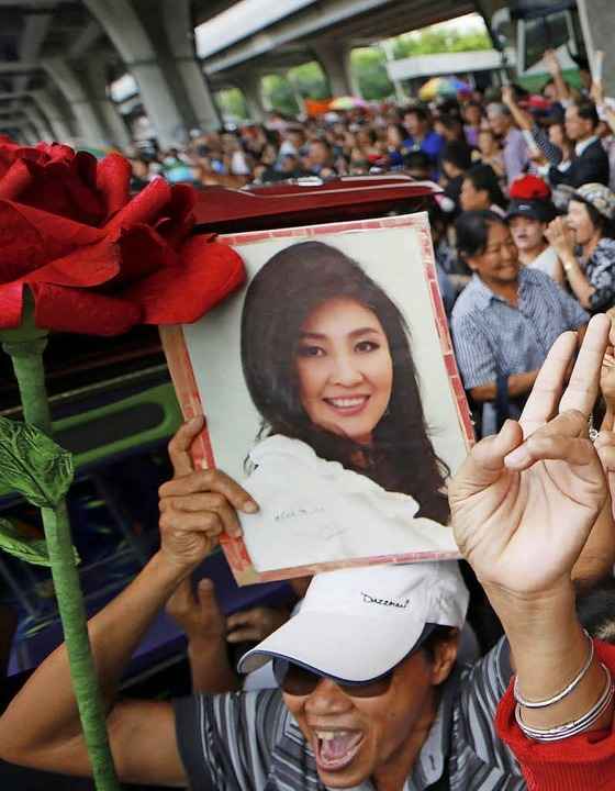 Ein Anh�nger zeigt das Bild von Yingluck Shinawatra.   | Foto: DPA