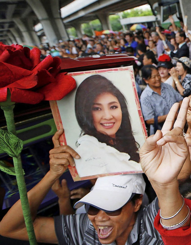 Ein Anhnger zeigt das Bild von Yingluck Shinawatra.   | Foto: DPA