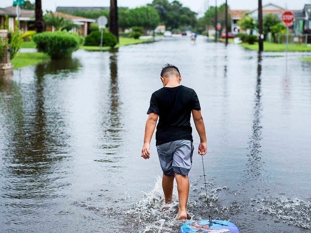 Ein Junge luft durch die berfluteten Straen von Galveston in Texas.  | Foto: AFP