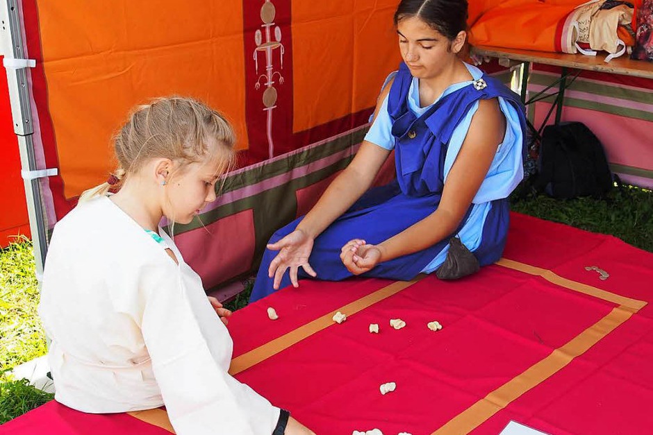 Alina Ackermann (rechts) zeigt den Besuchern, wie man das Knöchelspiel spielt. (Foto: Boris Burkhardt) Alina Ackermann (rechts) zeigt den Besuchern, wie man das Knöchelspiel spielt. (Foto: Boris Burkhardt)