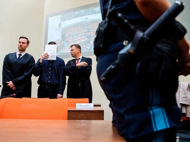 Der Angeklagte Philipp K. (M) steht am...ks im Landgericht im Verhandlungssaal.  | Foto: dpa