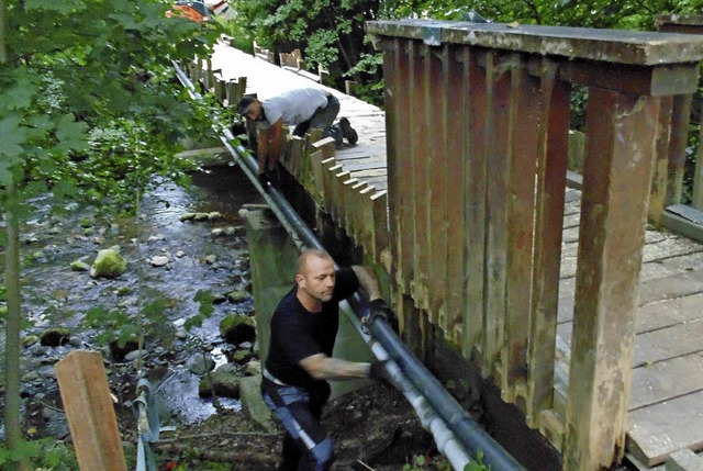 Vorarbeiter Tobias Holzheuer (vorne) u...en Abbrucharbeiten am Schwimmbadsteg.   | Foto: Michael Gottstein