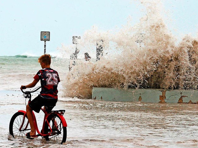 Ein Junge radelt  in Key West, Florida... berschwemmten Uferpromenade entlang.  | Foto: dpa