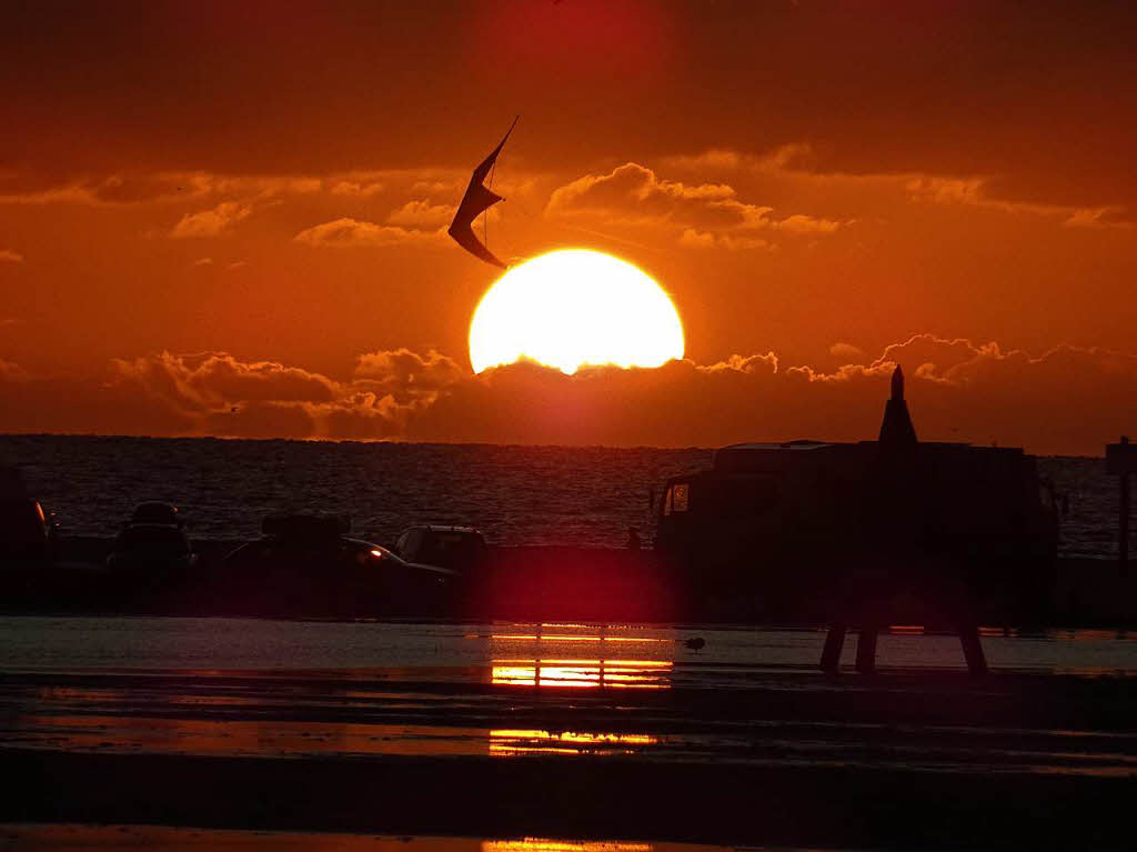 In der untergehenden Abendsonne ist ein Drachen zu sehen -  aufgenommen  bei einem  groen  Drachenfestival   am Strand  von  St. Peter-Ording   an der Nordsee.