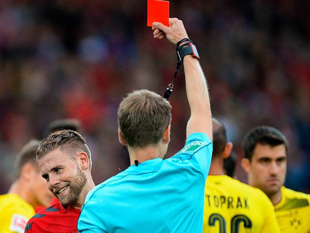 Schiedsrichter Cortus zeigt Yoric Ravet im Spiel gegen Dortmund die Rote Karte.  | Foto: dpa/Keller