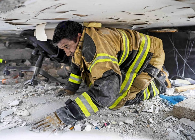 Bedrckend: Ein Feuerwehrmann sucht nach Verschtteten.   | Foto: dpa