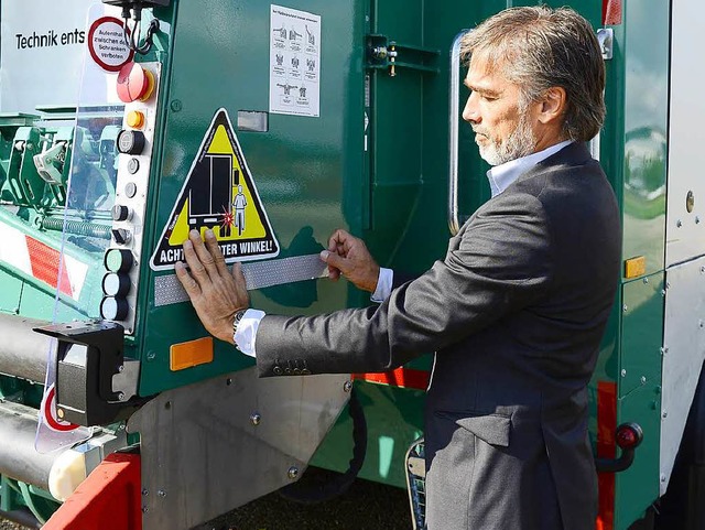 ASF-Chef Michael Broglin beklebt ein Fahrzeug der Abfallbeseitigung.  | Foto: Ingo Schneider