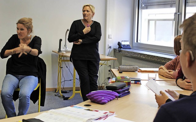 Eine Gebrdendolmetscherin (links) be...ose fr Ministerin Susanne Eisenmann.   | Foto: dpA/Erich Krieger