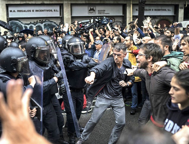 Die Stimmung ist angespannt: Menschen ... spanischen Nationalpolizei gegenber.  | Foto: dpa