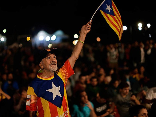 Ein katalonischer Senior hlt am Sonnt...ona die Fahne der Unabhngigkeit hoch.  | Foto: dpa