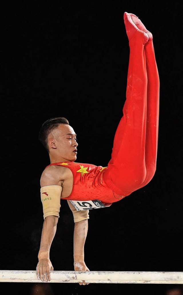 Der Mehrkampfweltmeister Xiao Ruoteng am Barren   | Foto: AFP