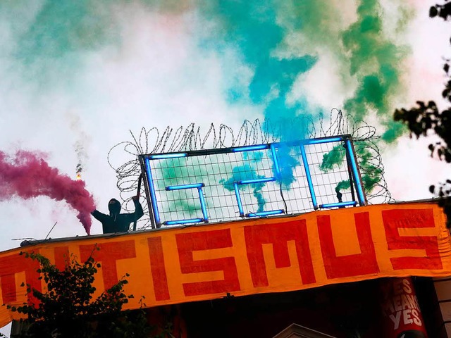 Ein Vermummter mit Bengalos protestiert gegen den G-20-Gipfel in Hamburg.   | Foto: dpa