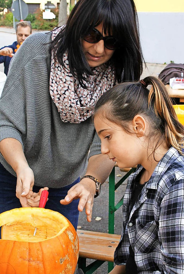 Um die  Krbisse in Form zu bringen, b...es Teamarbeit von  Eltern und Kindern.  | Foto: Lacher