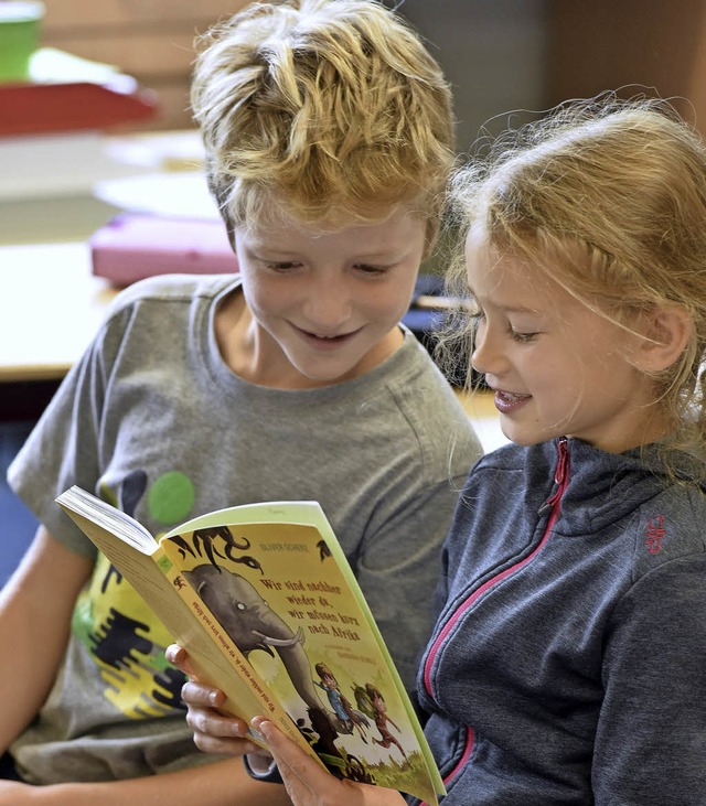 Finn (links) und Sophia lesen vor aus dem Afrika-Buch von Oliver Scherr.  | Foto: Thomas Kunz