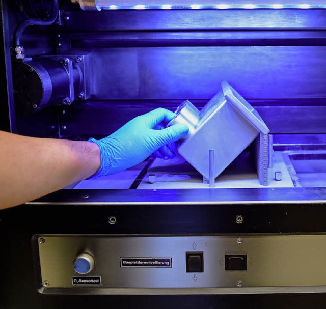 Ein Techniker entnimmt einem 3-D-Druck... fertig gedrucktes Bauteil eines ICE.   | Foto: Axel Heimken (dpa)