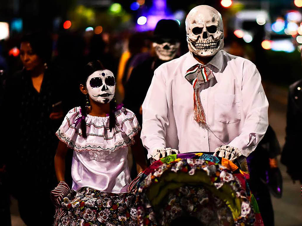 Bunte Totenkpfe und Riesenblumen im Haar. Die Catrina-Parade steht unter dem Motto 