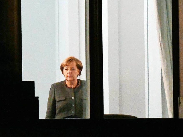 Kanzlerin Angela Merkel (CDU)  zeigt s... der Sondierungsgesprche am Fenster.   | Foto: DPA