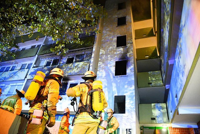 Einsatzkrfte der Feuerwehr vor dem Mannheimer Wohnhaus  | Foto: dpa