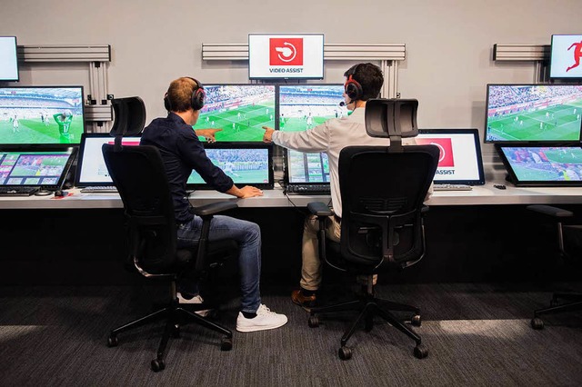 Ein Schiedsrichter und sein Operator i...vor Monitoren, die Spielszenen zeigen.  | Foto: dpa