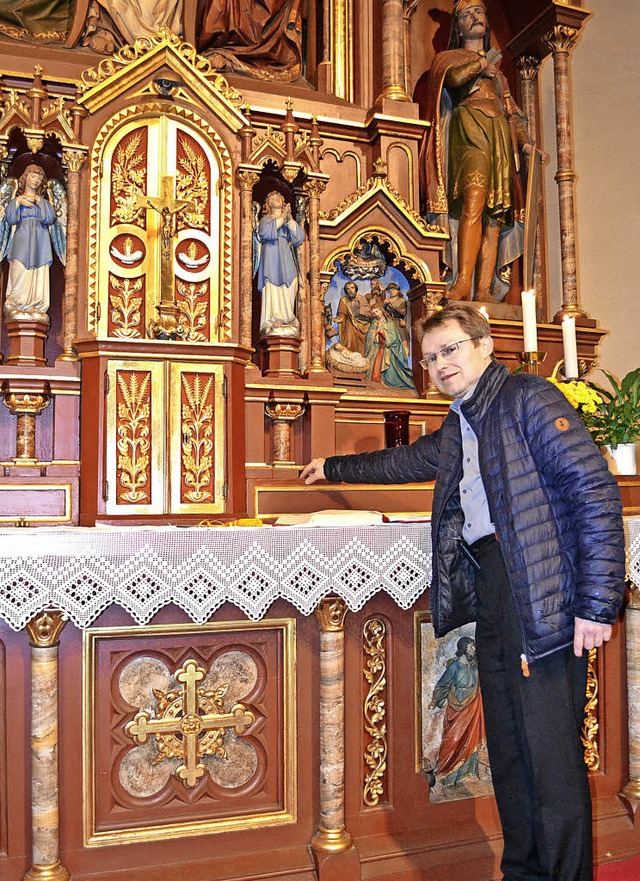 Pfarrer Frank Malzacher am kunstvoll geschaffenen Hochaltar der Hger Kirche.   | Foto: Paul Berger