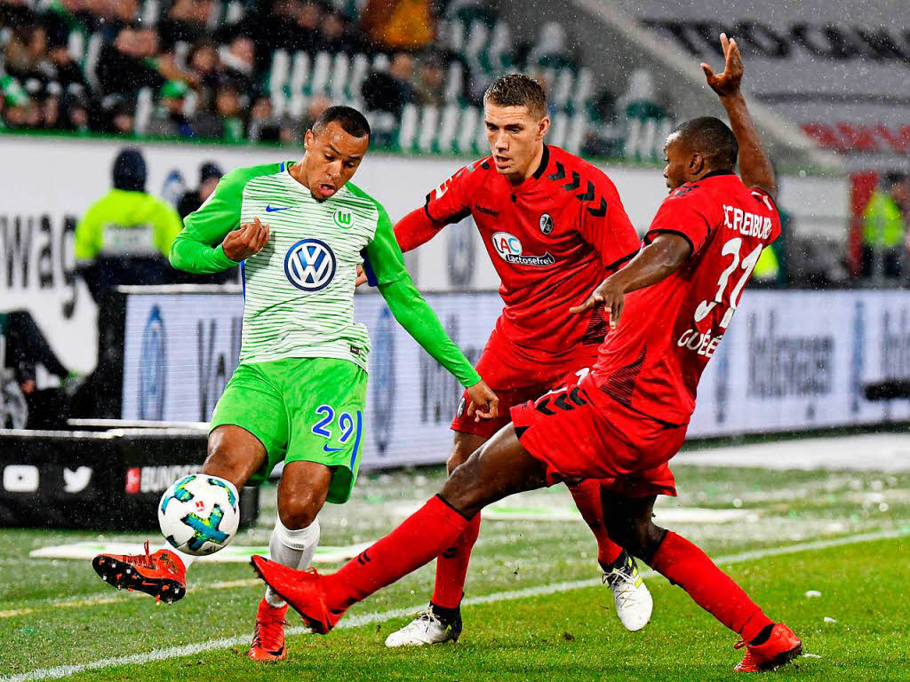 Karim Gud und Nils Petersen versuchen Wolfsburg Tisserand den Ball abzujagen.