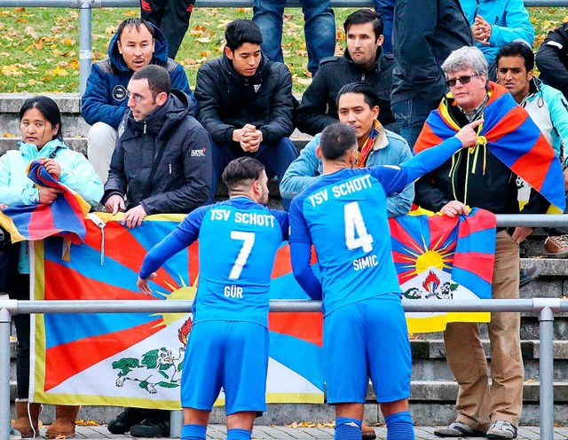 Mainzer Spieler sprechen mit Zuschauer... von China auf der Tribne hochhalten.  | Foto: dpa