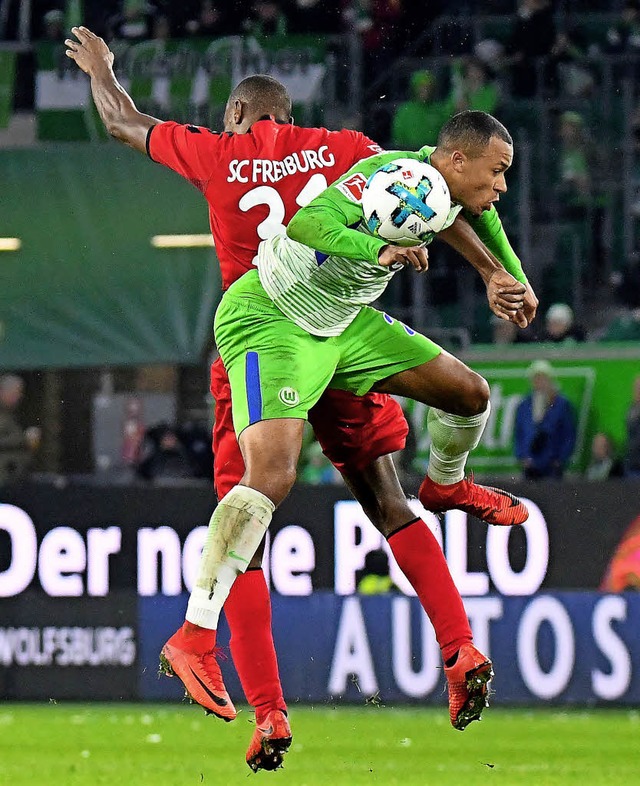 Den Gegner im Nacken: Freiburgs Karim ...mit dem Wolfsburger   Marcel Tisserand  | Foto: dpa