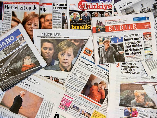 Merkel sitzt auf der Wippe und kmpft ...&#8211; Zeitungstitel aus dem Ausland.  | Foto: dpa