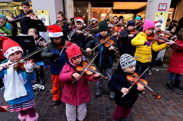 Mtze, Schal und Geige: Kinder beim Aktion-Weihnachtswunsch-Konzert in Freiburg  | Foto: Thomas Kunz