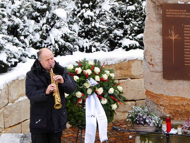 Mike Schweizer  spielt getragene Weisen am  Gedenkstein.  | Foto: Peter Stellmach