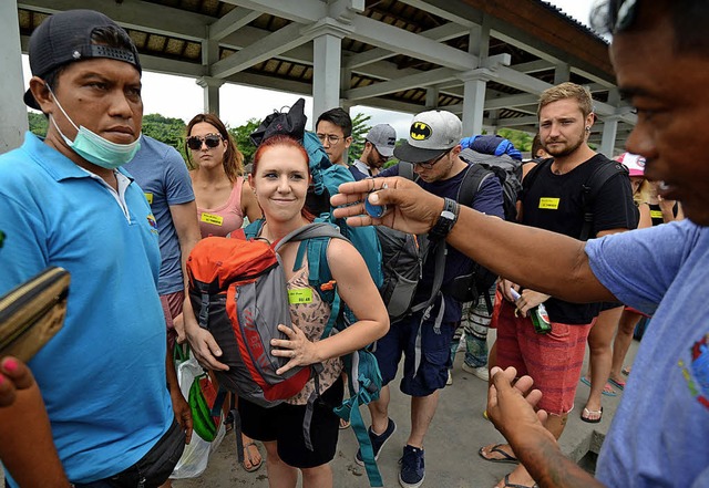 Diese Touristen wollen die Insel per Boot verlassen.   | Foto: afp