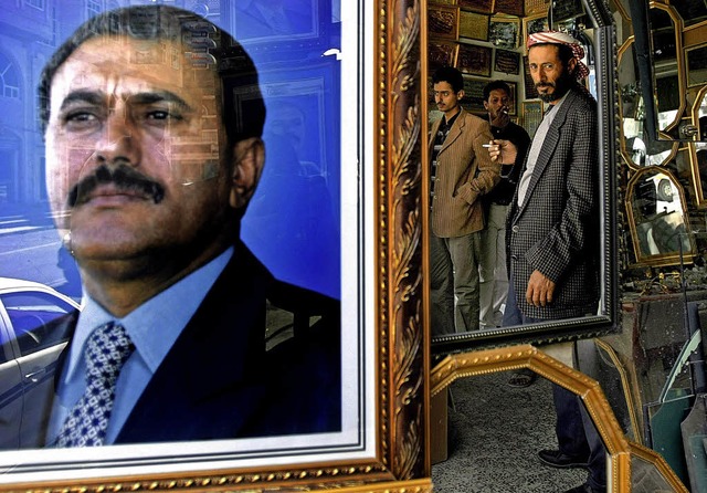 Jemeniten spiegeln sich im Jahr 2010 i...rfei des damaligen Machthabers Saleh.   | Foto: dpa