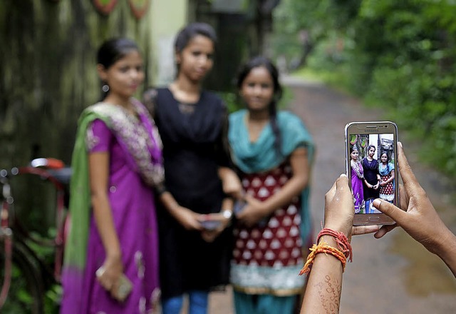 Ein Mdchen macht in Indien ein Foto ihrer Freundinnen.   | Foto: dpa